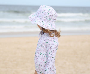 Sun hat and girls swimsuit in Floral Whisper at the beach